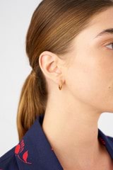 Profile view of model wearing the Oroton Caterina Medium Hoop in 18K Gold and Sustainably sourced 925 Sterling Silver for Women