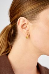 Profile view of model wearing the Oroton Caterina Textured Huggie in 18K Gold and Sustainably sourced 925 Sterling Silver for Women