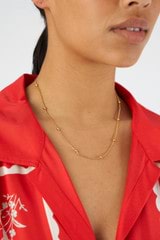 Profile view of model wearing the Oroton Sphere Necklace in 18K Gold and Sustainably sourced 925 Sterling Silver for Women