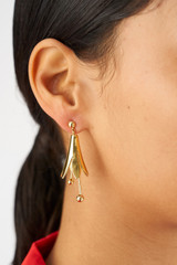 Profile view of model wearing the Oroton Lilium Drop Earrings in Shiny Gold and Brass for Women