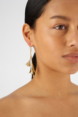 Profile view of model wearing the Oroton Lilium Thread Earrings in Shiny Gold and Brass for Women