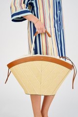 Profile view of model wearing the Oroton Callaway Straw Tote in Natural/Amber and Woven straw with leather trims for Women
