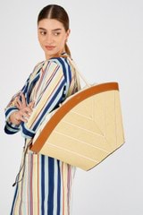 Profile view of model wearing the Oroton Callaway Straw Tote in Natural/Amber and Woven straw with leather trims for Women
