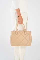Profile view of model wearing the Oroton Inez Quilted Medium City Tote in Praline and Smooth Leather for Women