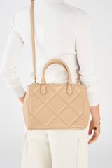 Profile view of model wearing the Oroton Inez Quilted Medium City Tote in Praline and Smooth Leather for Women