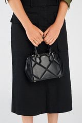 Profile view of model wearing the Oroton Inez Quilted Mini City Tote in Black and Smooth Leather for Women