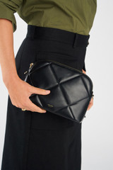 Profile view of model wearing the Oroton Inez Quilted Slim Crossbody in Black and Smooth Leather for Women