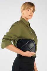 Profile view of model wearing the Oroton Inez Quilted Slim Crossbody in Black and Smooth Leather for Women