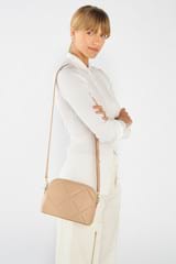 Profile view of model wearing the Oroton Inez Quilted Slim Crossbody in Praline and Smooth Leather for Women