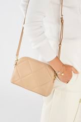 Profile view of model wearing the Oroton Inez Quilted Slim Crossbody in Praline and Smooth Leather for Women