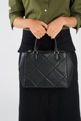 Profile view of model wearing the Oroton Inez Quilted Medium City Tote in Black and Smooth Leather for Women