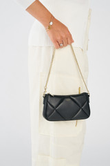 Profile view of model wearing the Oroton Inez Quilted Wristlet Clutch in Black and Smooth Leather for Women