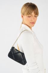 Profile view of model wearing the Oroton Inez Quilted Wristlet Clutch in Black and Smooth Leather for Women