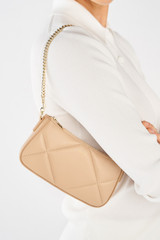 Profile view of model wearing the Oroton Inez Quilted Wristlet Clutch in Praline and Smooth Leather for Women