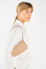 Profile view of model wearing the Oroton Inez Quilted Wristlet Clutch in Praline and Smooth Leather for Women