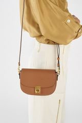 Profile view of model wearing the Oroton Yvonne Small Saddle Bag in Tan and Pebble Leather for Women
