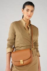 Profile view of model wearing the Oroton Yvonne Medium Day Bag in Tan and Pebble Leather for Women