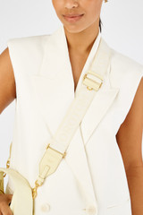 Profile view of model wearing the Oroton Fife Webbing Strap in Lemon Butter and Poly Jacquard webbing for Women