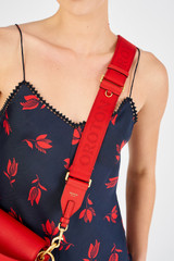 Profile view of model wearing the Oroton Fife Webbing Strap in Dark Poppy and Poly Jacquard webbing for Women
