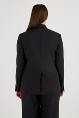 Profile view of model wearing the Oroton Black Fitted Blazer in Black and 53% Polyester 42% Wool 5% Elastane for Women