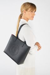 Profile view of model wearing the Oroton Polly Medium Zip Tote in Black and Pebble Leather for Women
