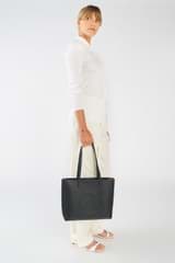 Profile view of model wearing the Oroton Polly Medium Zip Tote in Black and Pebble Leather for Women