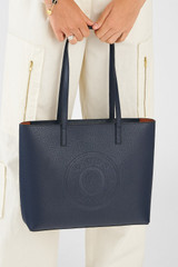Profile view of model wearing the Oroton Polly Medium Zip Tote in Dark Navy and Pebble Leather for Women