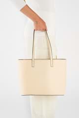 Profile view of model wearing the Oroton Polly Medium Zip Tote in Oatmeal and Pebble Leather for Women