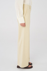 Profile view of model wearing the Oroton Flat Front Pant in Almond and 58% Viscose, 42% Cotton for Women