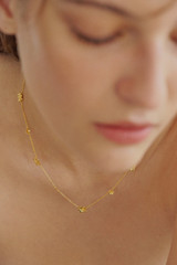Profile view of model wearing the Oroton Daisy Necklace in 18K Gold and Sustainably sourced 925 Sterling Silver for Women