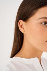 Profile view of model wearing the Oroton Lucia Studs in Worn Gold and Brass for Women