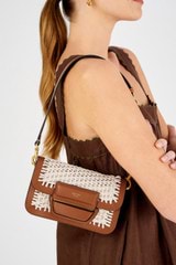 Profile view of model wearing the Oroton Dahlia Collectable Mini Day Bag in Amber and Smooth leather for Women