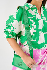Profile view of model wearing the Oroton Fife Webbing Strap in Jewel Green and Poly Jacquard webbing for Women