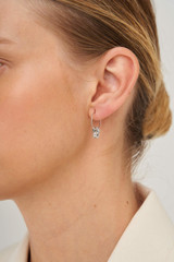 Profile view of model wearing the Oroton Leighton Mini Hoops in Silver and Brass for Women