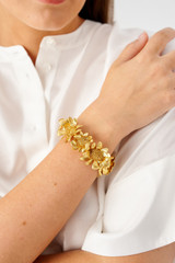 Profile view of model wearing the Oroton Peony Cuff in Worn Gold and Brass for Women