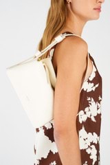 Profile view of model wearing the Oroton Caroline Small Day Bag in Paper White and Smooth leather for Women
