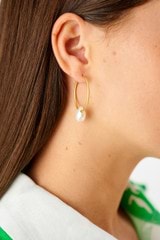 Profile view of model wearing the Oroton Marleigh Pearl Pendant Hoops in Gold and Brass for Women