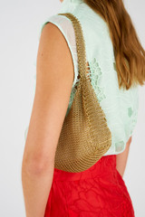 Profile view of model wearing the Oroton Edie Bag Worn Gold in Worn Gold and 100% metal for Women