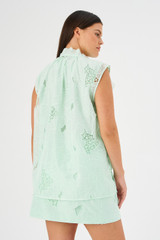 Profile view of model wearing the Oroton Tie Neck Lace Top in Sea Spray and 100% polyester for Women