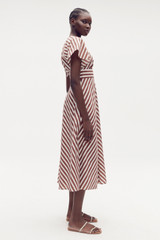 Profile view of model wearing the Oroton Sorrento Stripe Tie Dress in Deep Spice and 100% cotton for Women