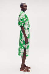 Profile view of model wearing the Oroton Silhouette Print A-Line Skirt in Jewel Green and 100% silk for Women