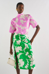 Profile view of model wearing the Oroton Silhouette Print A-Line Skirt in Jewel Green and 100% silk for Women
