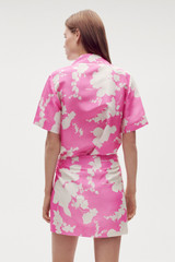 Profile view of model wearing the Oroton Silhouette Print Short Sarong Skirt in Carmine Pink and 100% silk for Women