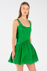 Profile view of model wearing the Oroton Short Tie Back Dress in Jewel Green and 100% cotton for Women
