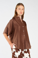 Profile view of model wearing the Oroton Short Sleeve Silk Dupion Overshirt in Deep Spice and 100% silk for Women