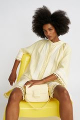 Profile view of model wearing the Oroton Loop Detail Smock Dress in Lemon Curd and 100% linen for Women