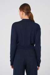 Profile view of model wearing the Oroton Long Sleeve Crop Cardi in North Sea and 100% Merino for Women