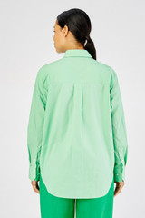 Profile view of model wearing the Oroton Poplin Long Sleeve Shirt in Apple and 100% cotton for Women