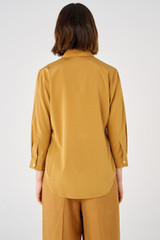 Profile view of model wearing the Oroton Stretch Silk 3/4 Sleeve Shirt in Brown and 92% silk, 8% spandex for Women