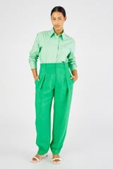 Profile view of model wearing the Oroton Pleat Pant in Jewel Green and 58% viscose, 42% linen for Women